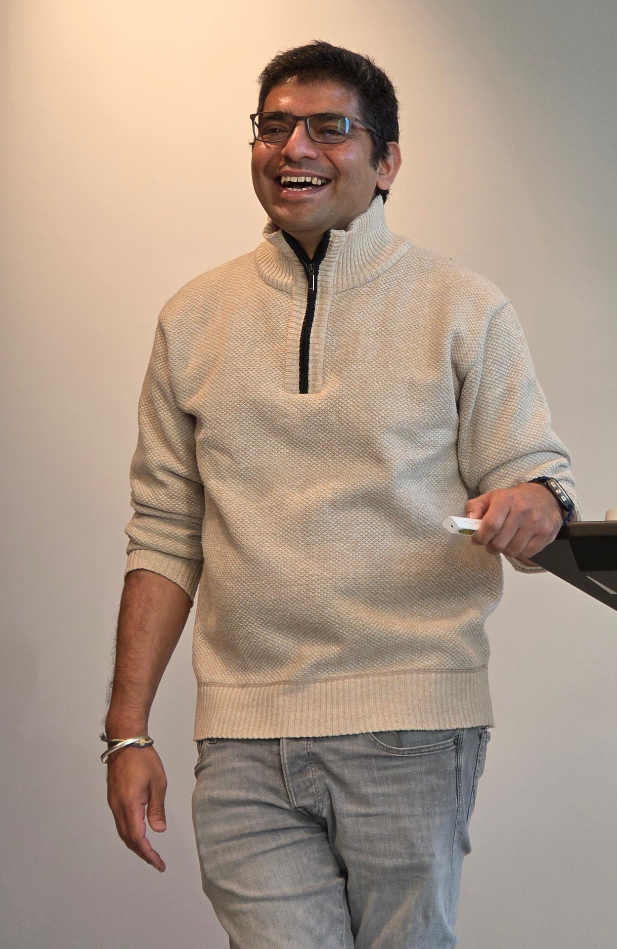 Dr. Raj Hegde smiling in a cream sweater